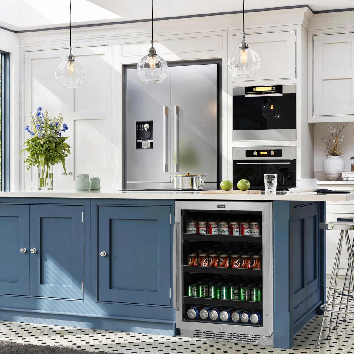 whynter-BBR-148SB-182-can-Beverage-Refrigerator, set in a bright kitchen with white cabinets, pendant lights, and a black-and-white patterned floor.